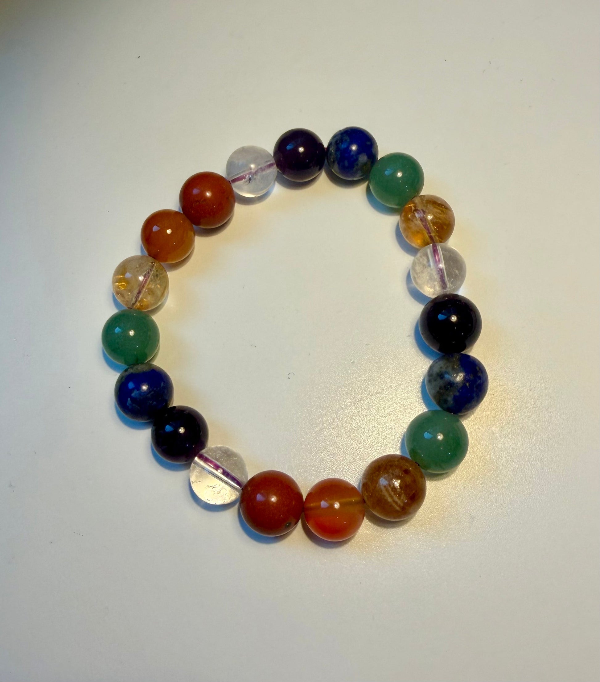 Close-up of the 7 Chakra Bracelet showing the polished natural gemstone beads on an elastic stretch cord