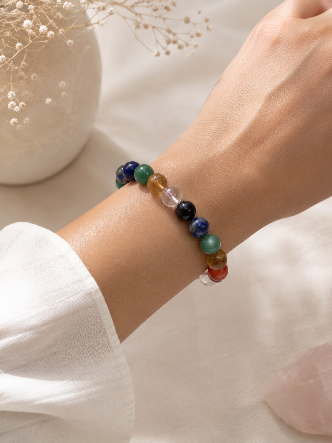 Woman wearing the 7 Chakra Bracelet, showing the polished gemstone beads in chakra colour order on the wrist