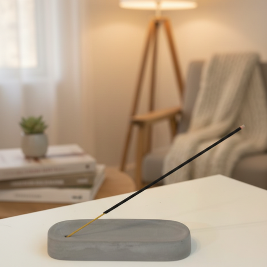 Incense stick on a concrete holder with a blurred living room background