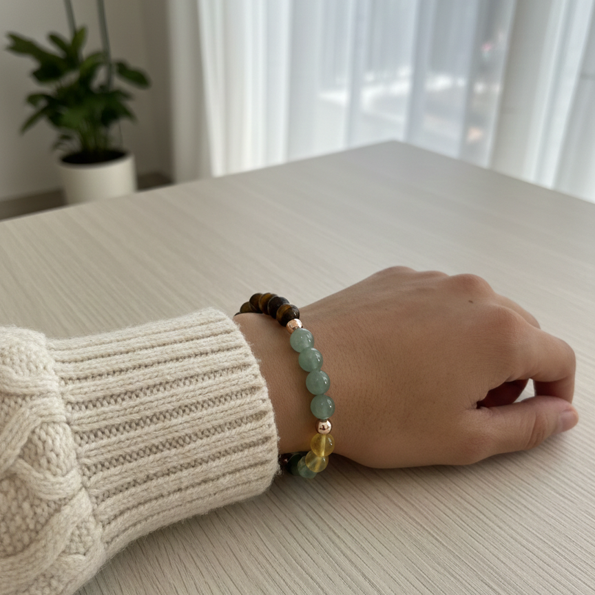 Hand wearing a bracelet on a light surface with a blurred background