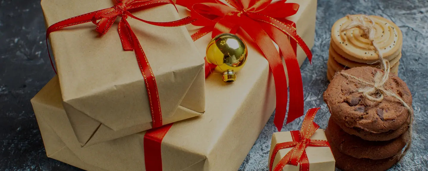 Stack of gift boxes with red ribbons and cookies