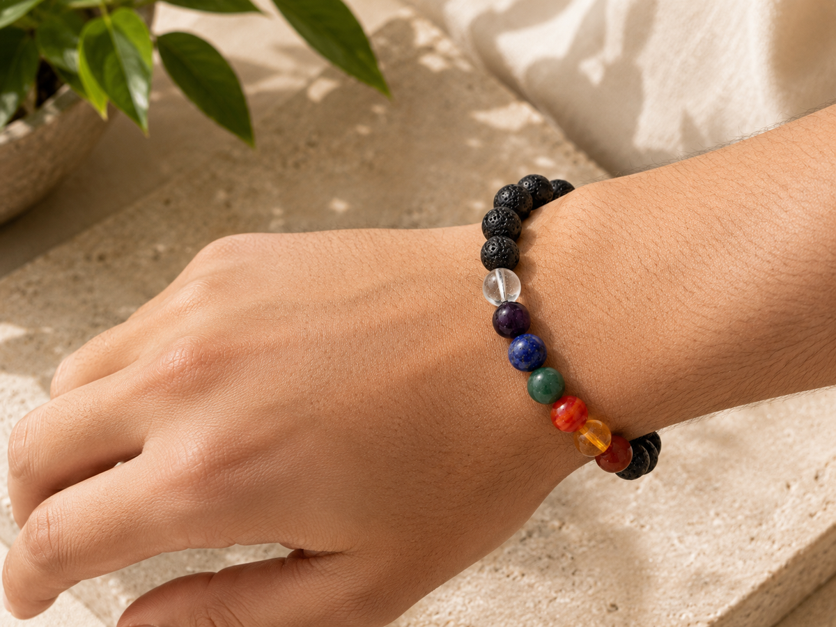 Lava Stone 7 Chakra Bracelet worn on a wrist, showing the black lava beads and the coloured chakra accent beads