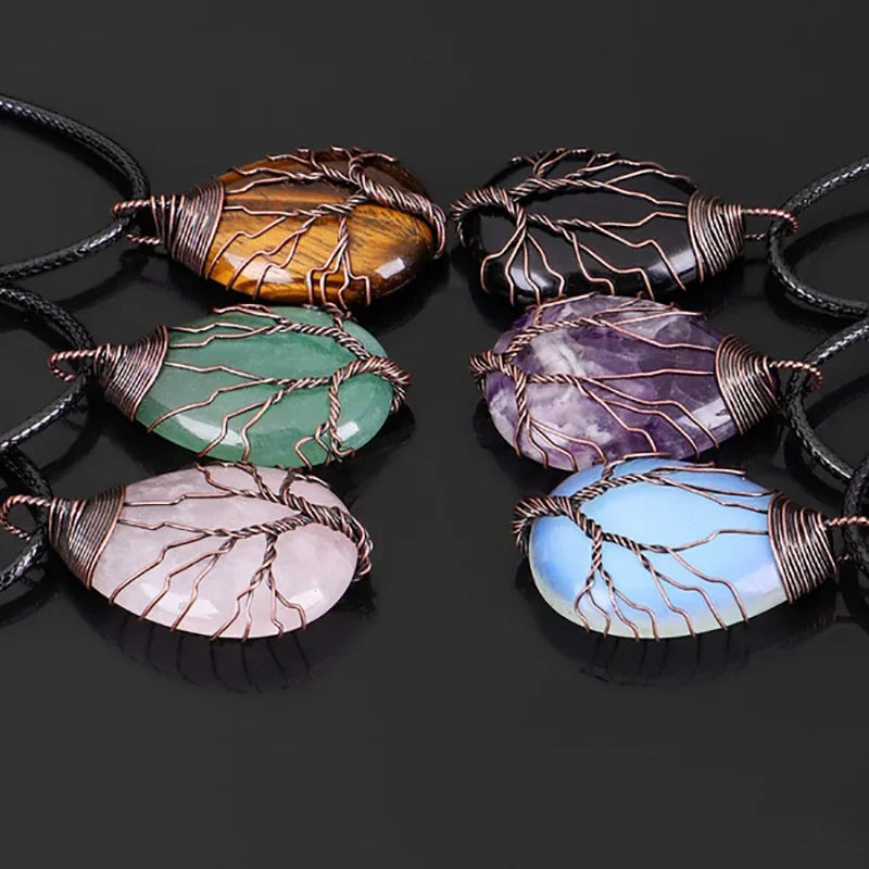 Close-up group of Tree of Life wire-wrapped gemstone pendants on black cords, showing the tree branches spreading across each stone